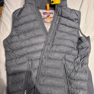 Svart dunväst från Parajumpers - Nu säljer jag denna väst åt min kille som inte har någon användning av den längre då han bara använder jackor. Som ni ser har den ett hål vid magen och dragkedjan som den har spillts cola på så den kan vara lite seg med att dra upp. Men annars inga problem och stilren, Äkta såklart men har tyvärr inte kvar kvitto och påse men köpt från johnells. Pris kan diskuteras