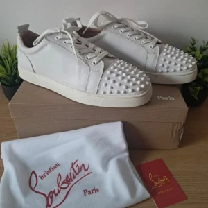 Christian Louboutin vita sneakers stl 45  - Snygga vita sneakers från Christian Louboutin med ikoniska röda sulor. Skorna  är tillverkade i skinn, vilket ger en lyxig känsla. Perfekt för dig som vill sticka ut med en och exklusiv look. Passar stl44 skriv om ni har frågor, kan diskutera pris 