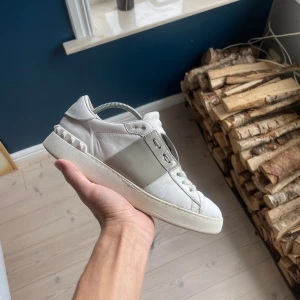 Valentino Open  - Säljer ett par Valentino Open sneakers i vitt skinn med grått band över mitten. Dom är väldigt slitna som ni ser på bilderna och därav priset. Först till kvarn 
