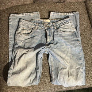 Midwaist jeans - Ljusblå jeans i bootcut modell och midwaist med fem fickor. Jeansen har en ikonisk knappgylf och är tillverkade i slitstarkt denim. Perfekta för en avslappnad och tidlös look.