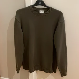 Olivgrön stickad tröja John Henric - Snygg olivgrön stickad tröja från John Henric i storlek S. Tröjan har rund hals, ribbade muddar vid ärmslut och nederkant samt långärmad passform. Perfekt för dig som gillar stilrena och enkla plagg med en chill vibe. (Nypris ca 990:-)