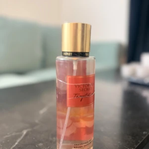 Victoria's Secret Temptation mist - Fräsch och trendig body mist från Victoria's Secret. Perfekt för dig som vill ha en lätt och ungdomlig doft att spraya på när som helst. Snygg flaska som passar i väskan. Volym och ingredienser syns ej tydligt på bilden.