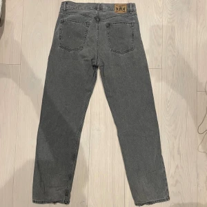 Grå Sweet SKTBS jeans loose fit - Gråa Sweet SKTBS jeans med loose passform och klassisk femficksdesign. Jeansen har en snygg vintage-look, normalhög midja och är tillverkade i robust denim. Perfekta för en avslappnad och stilren vibe.