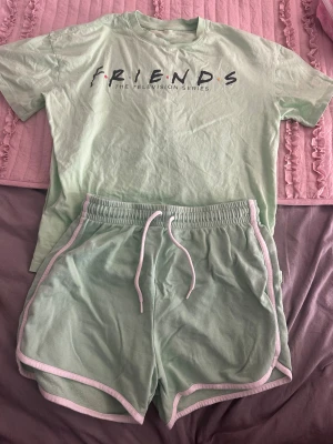 Mintgröna shorts med vit kant - Snygga mintgröna shorts med vit kant och snörning i midjan. De har en loose passform och är gjorda i mjuk bomull, perfekta för chill dagar eller träning. Sportig look med elastisk midja och rundade benkanter.