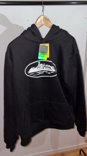 Svart hoodie från Corteiz  - Svart Corteiz-hoodie – helt ny med originaltaggar! Aldrig använd, i perfekt nyskick. Klassisk CRTZ-hoodie med det ikoniska trycket på bröstet och mjuk, bekväm passform. Passar dig som vill ha streetwear i toppskick direkt från garderoben – oanvänd och ready to go. PRIS GÅR STT DISKUTERAS!