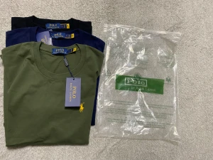 Polo Ralph Lauren t-shirt, 3-pack - Snygga t-shirts från Polo Ralph Lauren i tre färger: olivgrön med gul broderad logga, marinblå med röd broderad logga och svart. Alla har rund hals, korta ärmar och är gjorda i mjuk bomull. Perfekt för dig som gillar klassisk stil med en modern touch.   Skickas samma dag eller nästa dag 🤩.                                      Slim fit 