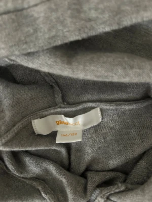 Grå hoodie  - Säljer en grå hoodie från Gina Tricot med vita stjärnor på bröstet och en stor stjärna på ryggen. Tröjan har huva och är långärmad, perfekt för chill dagar. Mjuk och skön känsla, passar dig som gillar enkel men snygg stil.