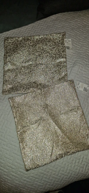 Kuddfodral - Två super fina helt nya kuddfodral med dragkedja i fint guldigt sprickigt mönster, måtten är 40×40. 