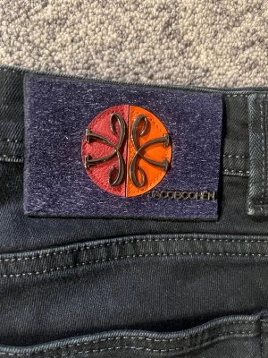 Svarta jeans från Jacob Cohen, strl 32 - Limited edition svarta jeans från Jacob Cohen med exklusiva detaljer och paisleymönstrat innerfoder. Snyggt smal passform och klassisk femficksdesign. Märkets ikoniska patch baktill i rött och orange med metallogo. Perfekt för dig som gillar premium och unik stil.