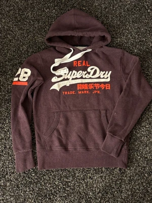 Vintage superdry hoodie (sällsynt) - Säljer nu denna sjukt eftertraktade superdry hoodie. Skick 8/10 med lite slitet tryck eftersom den är så svår att få tag på. Obs kan gå ner i pris vid snabb affär!
