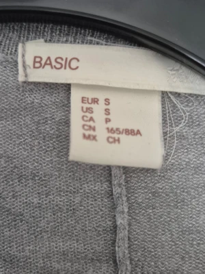 Kofta - En enkel och chill grå kofta från KappAhl i storlek S. Modellen är öppen framtill utan knappar och har långärmade ärmar. Materialet är mjukt och stickat, perfekt för lager på lager. Passformen är loose och koftan har en snygg, avslappnad look.