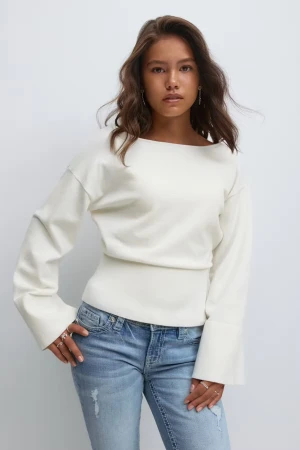 Vit långärmad tröja med breda ärmar - Snygg vit långärmad tröja med breda, utsvängda ärmslut och rak halsringning. Tröjan har en ribbad midja som ger en cool siluett och är tillverkad i mjukt bomullsmaterial. Passar perfekt till jeans eller mjukisbyxor för en chill look. Storlek 158/164