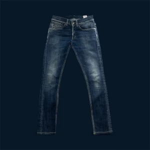 Dondup George Jeans - Snygga blå Dondup jeans med skinny passform och klassisk femficksdesign. Jeansen har slitna detaljer och tvättad look, med dragkedja och knapp i midjan. Perfekta för dig som gillar en smal siluett och stilren denim.