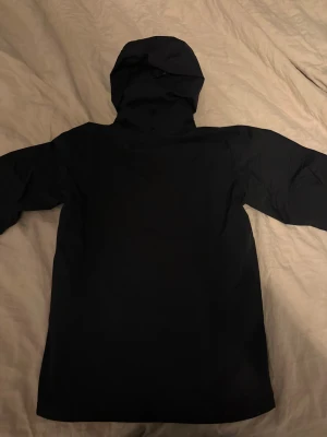 Svart Arc'teryx beta AR - Arc'teryx svart Beta AR med Gore-Tex Pro-material, huva och flera dragkedjeförsedda fickor. Snyggt Arc'teryx-logo på bröstet och detaljerad insida med extra ficka. Perfekt för dig som gillar outdoor och vill ha en jacka med clean look. Bra skal till skidåkning 