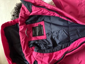 Overall från Didrikson 1913 - Didriksons overall är ett pålitligt val för vinterns alla äventyr, från snölek till skidåkning. Med varm, isolerande fodring och en rad smarta funktioner håller overallen barnet både skyddat och bekvämt oavsett väder. Overallen har en ergonomisk passform, justerbara detaljer och en smart "Extend size"-funktion som gör att ärmar och ben kan förlängas upp till en storlek (ej utnyttjad). En lagning under luvan (kan döljas med hjälp av tygmärke).