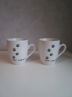 2st muggar  - Säljer 2st muggar från panda collection med tassar på, perfekt för kaffe eller te. Den ena muggen har ett litet märke på sig (se bild)