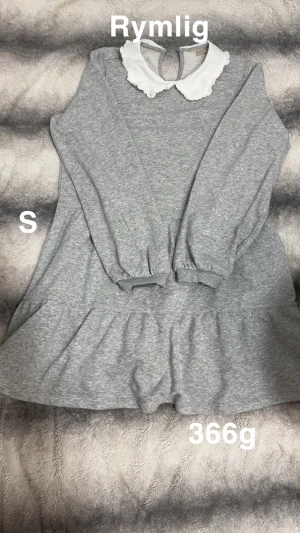 Grå klänning med vit krage - Supersöt grå klänning med volangkjol och lång ärm. Har en vit, söt krage med volangkant och knapp i nacken. perfekt för dig som gillar en gullig och avslappnad stil.🌸Fint använt skick. Rymlig Storlek s