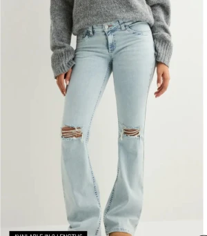 Bootcut jeans från Nelly ljusblå - Säljer ett par ljusblå bootcut jeans från Nelly med låg midja. Har aldrig använt. Jeansen har klassisk femficksdesign och snygg broderad detalj i rosa på bakfickan. Materialet är jeans och passformen är loose med bootcut ben. Sälja den eftersom den är lite för kort för mig