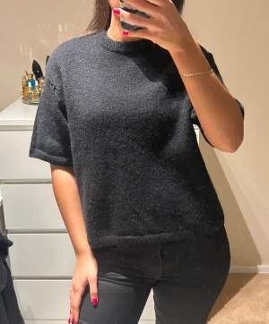 Svart stickad tröja med kort ärm - En svart stickad tröja med korta ärmar från Gina Tricot i storlek S!!