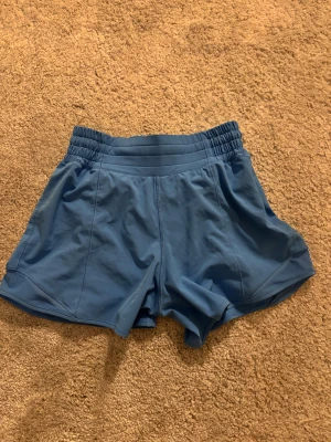 Blå träningsshorts från Lululemon - Säljer ett par blå träningsshorts från Lululemon i storlek 2. De är helt nya andvända 5 gånger
