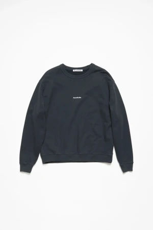 Svart sweatshirt från Acne Studios - Svart sweatshirt från Acne Studios med diskret logotyp broderad på bröstet. Tröjan har rund hals, ribbade muddar och lång ärm. Tillverkad i mjuk bomull för en skön och avslappnad känsla. Perfekt för en clean och stilren look. Tröjan är i nytt skick. Original pris 3500kr