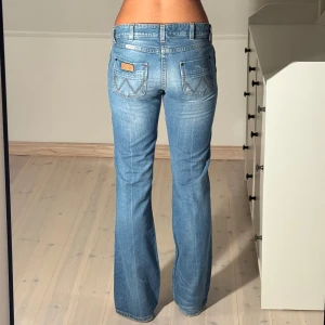 Low flared wrangler jeans  - Midjemått: 38cm. Innerbenslängd: 79cm. (Storlek 27.) Aningen slitna benslut, se sista bilden.)