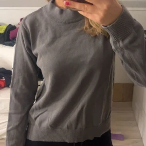 Grå tröja från WAY INK - En stilren grå tröja från WAY INK (köpt från kidsbrandstore) med högre ribbad krage och långa ärmar. Tröjan har en enkel design utan mönster och är tillverkad i ett mjukt material som känns skönt mot huden. Perfekt för kyligare dagar.🤩❤️storlek 170 men passar S