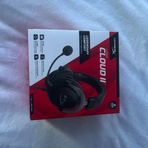 HyperX Cloud II - HyperX Cloud II gamingheadset med virtuellt surroundljud, minnesskum, avtagbar mikrofon och aluminiumram. Passar PC, PS4/PS5. Headsetet ser ut att vara i nyskick och levereras komplett i originalförpackning. Perfekt för spel och kommunikation.
