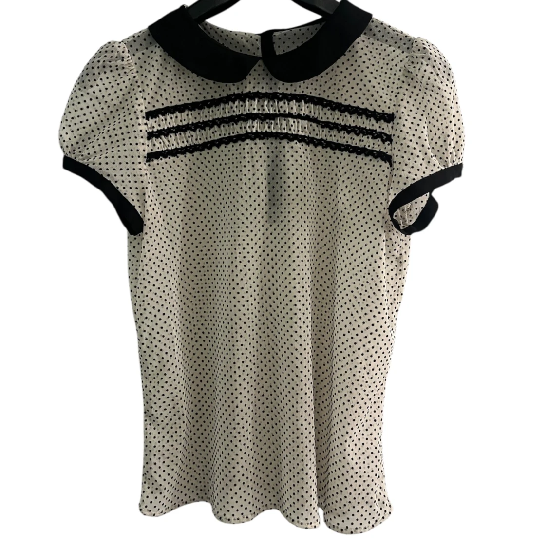 Prickig blus med svart krage