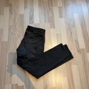  Lee jeans 32/30 - Säljer ett par svarta jeans från Lee med klassisk femficksdesign och raka ben. Jeansen har normal passform och är tillverkade i ett mjukt denimtyg som sitter skönt. Perfekta för dig som gillar en stilren look med diskreta detaljer.