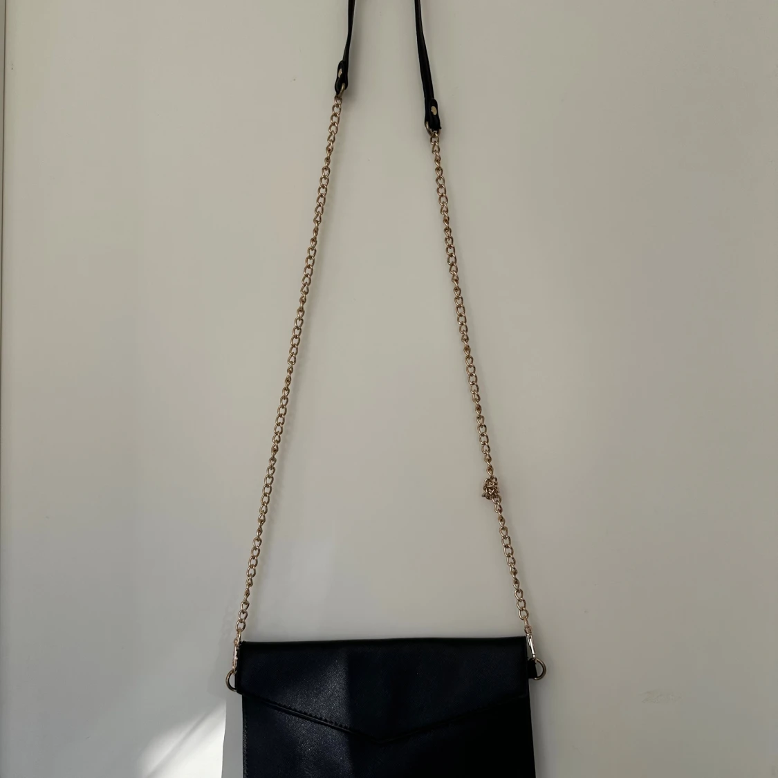 Svart kuvertväska med guldkedja
