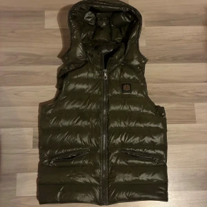 Bvaldi väst - Bvaldi väst olivgrön, säljs ej längre nypris 1899. M true to size. Avtagbar luva, 