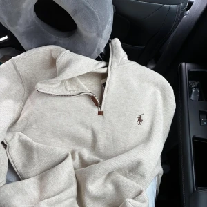 Polo Ralph lauren half zip  - Säljer en stilren beige quarter-zip tröja från Polo Ralph Lauren. Tröjan har lång ärm, klassisk broderad logga på bröstet. Är helt ny endast provad men köpt i fel storlek då den var för liten. NYPRIS 2 295kr! 