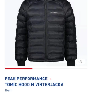 Svart Peak Performance dunjacka S - Peak Performance Tomic Hood dunjacka i svart med huva och dragkedja. Jackan är quiltad och har logga på bröstet och ärmen. Perfekt för kalla vinterdagar och har en clean, sportig look.