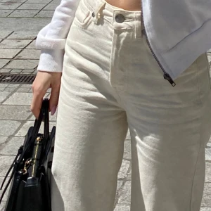 Vita raka jeans från Bik Bok - Snygga vita jeans från Never Denim med raka ben och hög midja. Jeansen har klassisk femficksdesign och är tillverkade i ett mjukt bomullstyg. Perfekta för en clean och fräsch look.