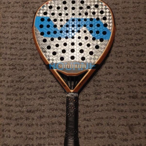Padel rack - Säljer mitt Varlion LW Summum Hexagon Rhombus padelracket i fint begagnat skick. Rund form med grym kontroll och stabil känsla, gjort i kolfiber med Rhombus Fiber-teknik. Stilren design i silver, blått och koppar. Perfekt för dig som vill ha ett kvalitetsracket med bra balans och precision.