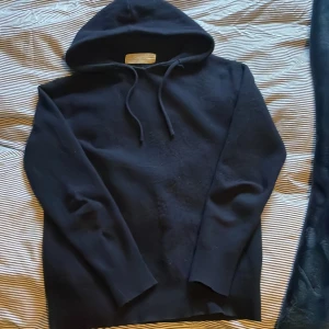 Mörkblå kashmirhoodie från Sayles - Mysig mörkblå hoodie från Sayles i lyxig kashmir. Klassisk modell med huva och dragsnören, samt långa ärmar. Perfekt för dig som vill ha en stilren och bekväm tröja med premiumkänsla. Snygg passform och supermjuk känsla. Jag tror att det var storlek Xs men den krymptes i tvätten så passar bra till 145-155. Jag på bild är 153.