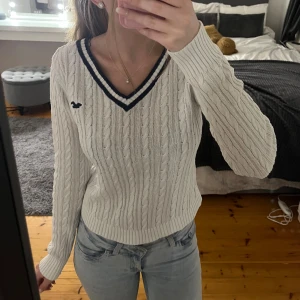 Stickad tröja Hollister - En vit stickad v-ringad tröja från Hollister med mörkblåa ränder. Den är i storlek S och har använts ett fåtal gånger. 💗