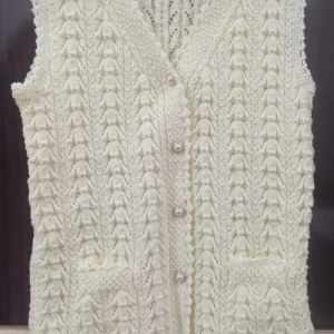 Vit stickad väst med pärlknappar - Säljer en vit stickad väst med snyggt strukturmönster och pärlknappar framtill. Västen har två praktiska fickor och v-ringad hals. Perfekt för att addera lite vintagekänsla till din outfit.Ny och oanvänd 
