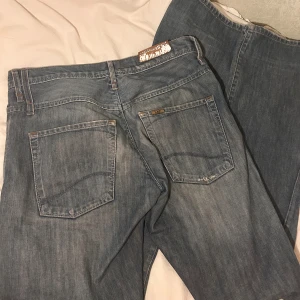 Ljusblå Lee jeans bootcut/raka jeans  - Säljer ett par ljusblå jeans från Lee med klassisk femficksdesign och bootcut-ben men ändå relativt raka i modellen. Jeansen har en snygg tvättad look och Lee-logga på bakfickan. Köpte på vinted men passade inte mig. Lite slitningar vid hällarna men inget man tänker på. De är långa i benen. Jag köpte dem för 350 kr