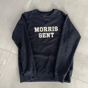 Morris tröja - Tja! Säljer en mörkblåsweatshirt från Morris Gents i storlek medium. Tröjan har klassisk rund halsringning och stora vita bokstäver broderade framtill. Tillverkad i mjuk bomull med långa ärmar och ribbade muddar vid ärmslut och nederkant. Perfekt för en chill och stilren look. Tröjan är i mycket bra skick och inga tecken på användning! Sitter bra på mig som är 185! Säljs för endast 249kr! Hör av dig vid minsta lilla fundering! Mvh EM_resell