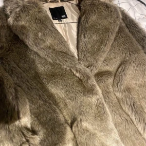 Beige pälsjacka från 157, stl S - Säljer en fluffig och snygg beige pälsjacka från 157 i storlek S. Jackan har bred krage och är helfodrad med ljus insida. Perfekt för dig som vill ha en varm och trendig look under kyliga dagar.