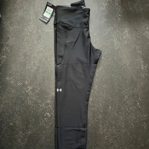 Ankle leggings från Under Armour - Svarta ankle leggings från Under Armour med hög midja och kompressionseffekt. Stl L                 Helt ny
