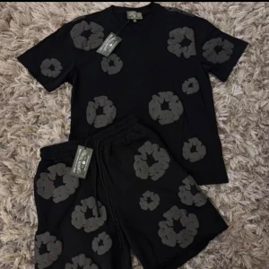 Svarta shorts med grått blommönster - Svarta shorts från Represent med stora gråa blommönster över hela tyget. Modellen har elastisk midja med snörning och en loose passform. Perfekta för en avslappnad och trendig stil.