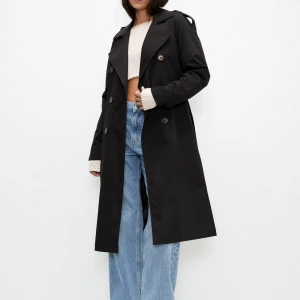 Svart trenchcoat från Pull&Bear - Svart lång trenchcoat från Pull&Bear med knappar. Perfekt ny till hösten. Helt nyskick men lappen är ej kvar.