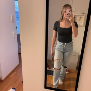 Mörkgrå croppad topp med fyrkantig ringning - Snygg mörkgrå croppad topp med korta ärmar och fyrkantig ringning. Den är nopprig men annars är den i bra skick. Annonsen finns på flera ställen så skriv till mig innan ni trycker på köp🫶🏻