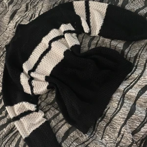 Randig stickad tröja från SHEIN - Säljer en svart och vit randig stickad tröja från SHEIN. Tröjan har långärmade ärmar och breda ränder över hela plagget. Den är mjuk och har en luftig stickning som ger en cool och avslappnad vibe.