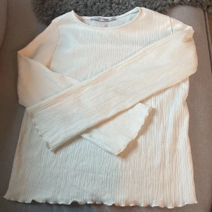 Vit långärmad topp från 157 storlek 150 - Säljer en vit långärmad topp från 157 med crinklad struktur och vågig kant. Ska tvättas innan jag skickar efter!