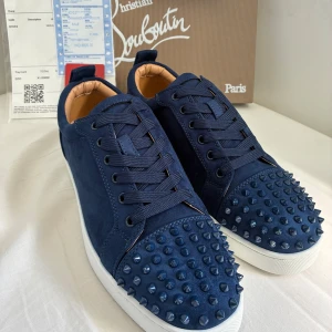 Christian Louboutin Skor (navy) - Säljer mina Christian Louboutin Skor i navy blue suede med spikar, Skorna är i nytt skick och allt som finns på bilden medföljer. Skorna är i Storlek 43