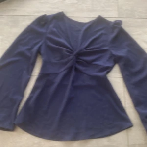 Mörkblå blus med v-ringning  - Snygg mörkblå blus med v-ringning och twistad detalj framtill. Stl XS men skulle själv säga att den funkar för S också! 
